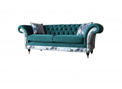 Een liewegt Tressëtz-Sofa aus Chesterfield an engem zarten Smaragdgréng mat Blummenmuster.