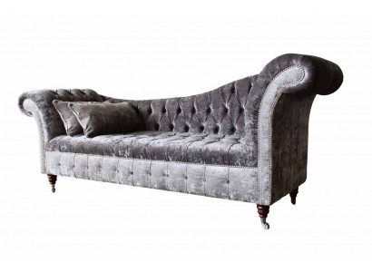 E bëqueemt, klassescht Sofa am Chesterfield-Stil an engem déif Sëlwertéin.
