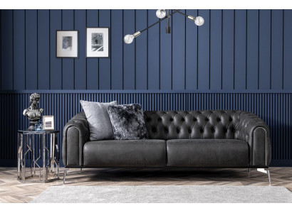 Schwaarzt riicht Viersëtzer-Sofa am Chesterfield-Stil fir de Living.