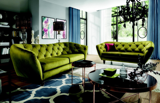 Dreiplaz-Sofa mat luxuriéiser Chesterfield-Récklehne an engem eleganten gréngoen.