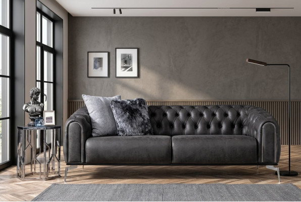 Schwaarzt riicht Viersëtzer-Sofa am Chesterfield-Stil fir de Living.