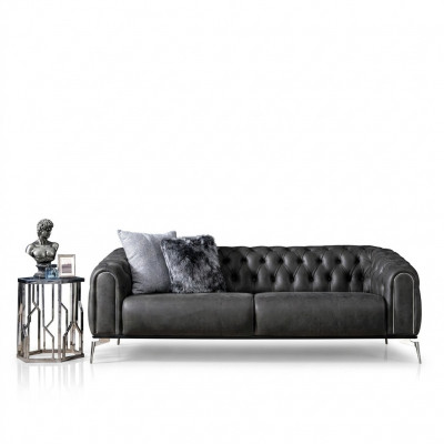 Schwaarzt riicht Viersëtzer-Sofa am Chesterfield-Stil fir de Living.