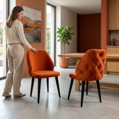 Gepolsterte Holzstull orange Chesterfield op schwaarze Been d'Iesszëmmer