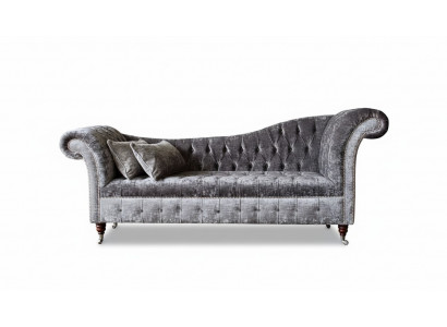 E bëqueemt, klassescht Sofa am Chesterfield-Stil an engem déif Sëlwertéin.