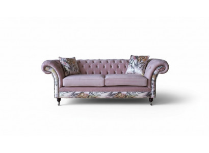 E bëschtenegt Chesterfield-Dreplazerschof mat engem zaarten rosa Blummemuster.